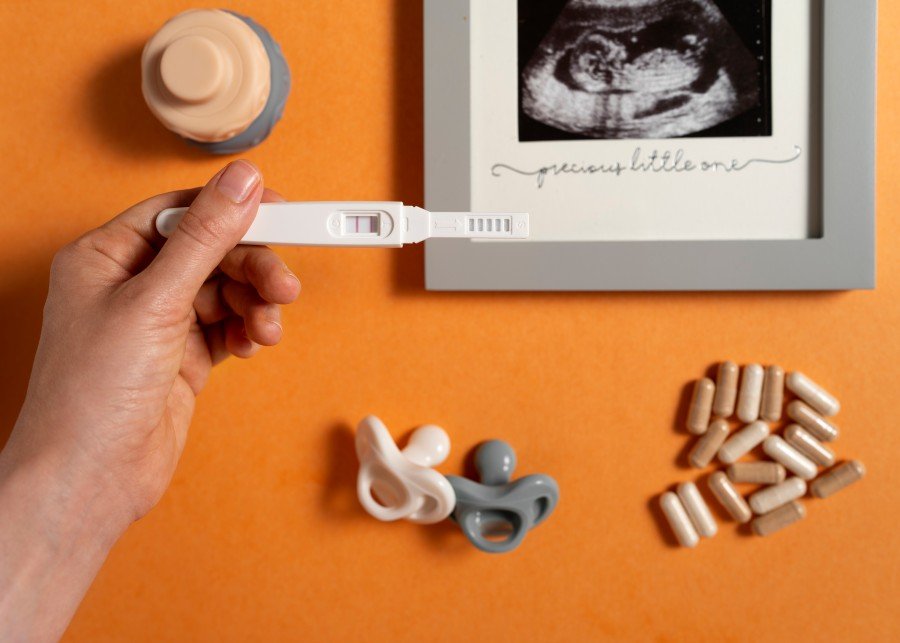 Positive pregnancy test with ultrasound image and baby accessories