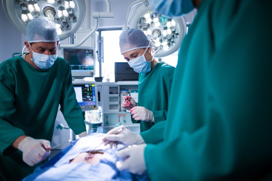 Surgeons in protective gowns and masks performing an operation in a modern operating room